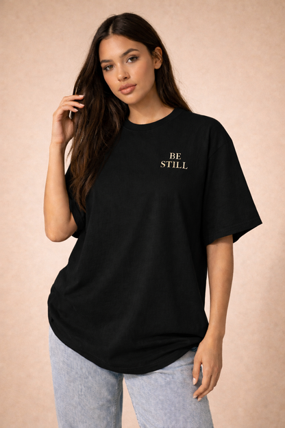 Oversized vintage black t-shirt with ‘Be Still’ faith design for women